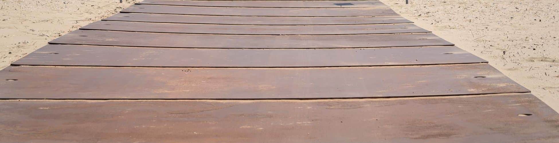 zware stalen rijplaten op het strand voor parkeerplaats
