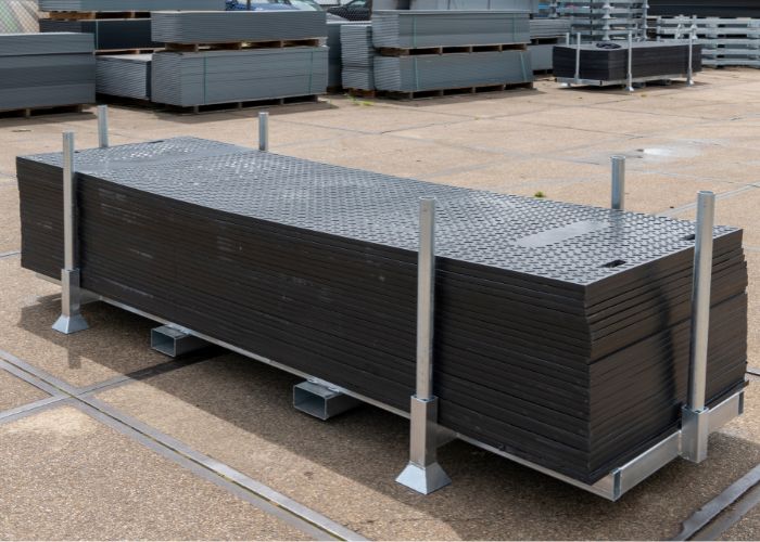 Kunststof-rijplaten-huren-of-kopen Stapel kunststof rijplaten in een stapelbox voor bouwplaatsen en tijdelijke rijwegen
